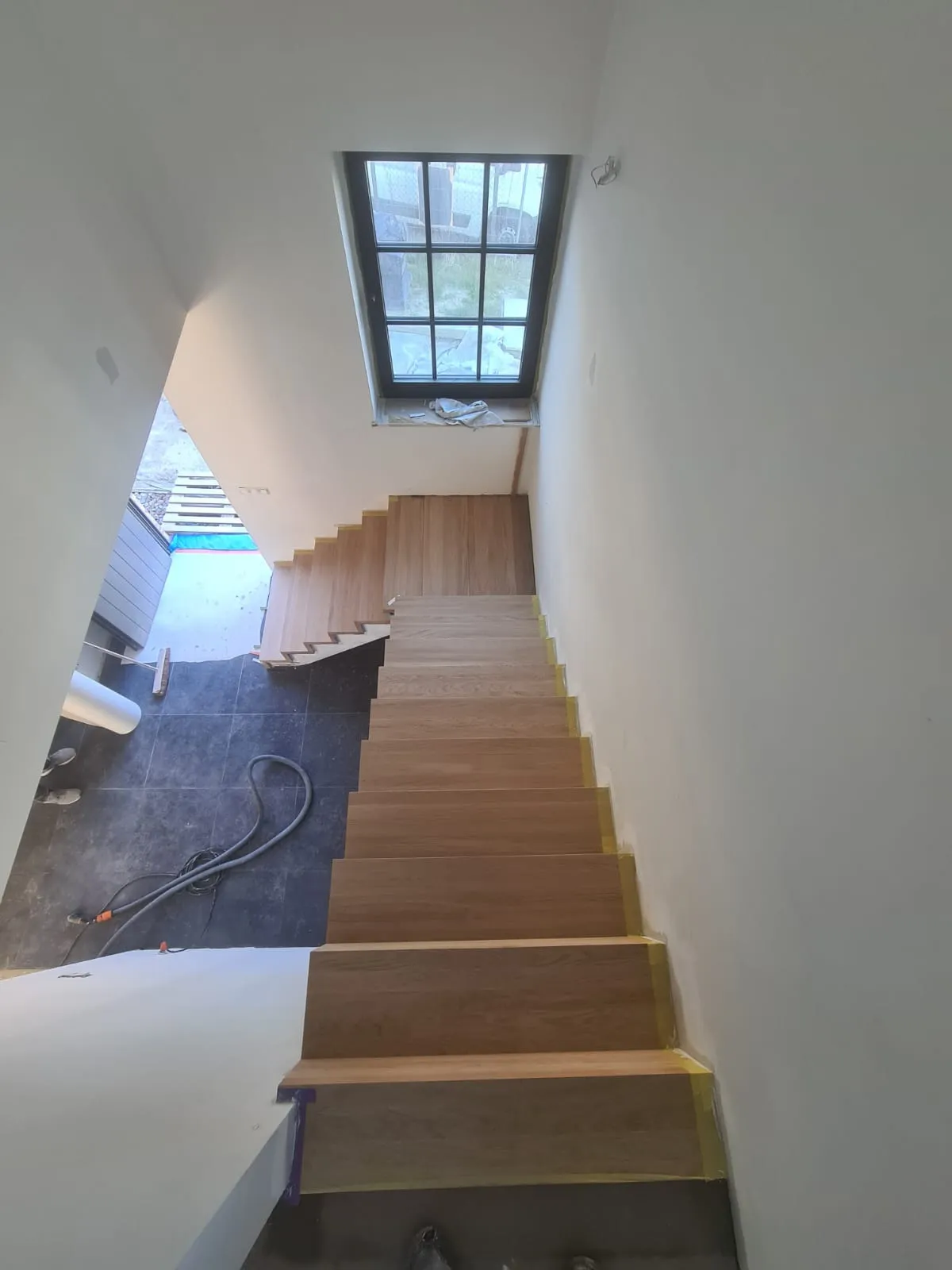 Escalier en chêne en cours de pose, ruban de protection sur les contremarches